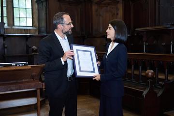 Professor Nicolai Sinai, Vice-Chair of the Faculty, presents Ms Mirziyoyeva with a recognition of her work towards the criminalisation of domestic violence in Uzbekistan